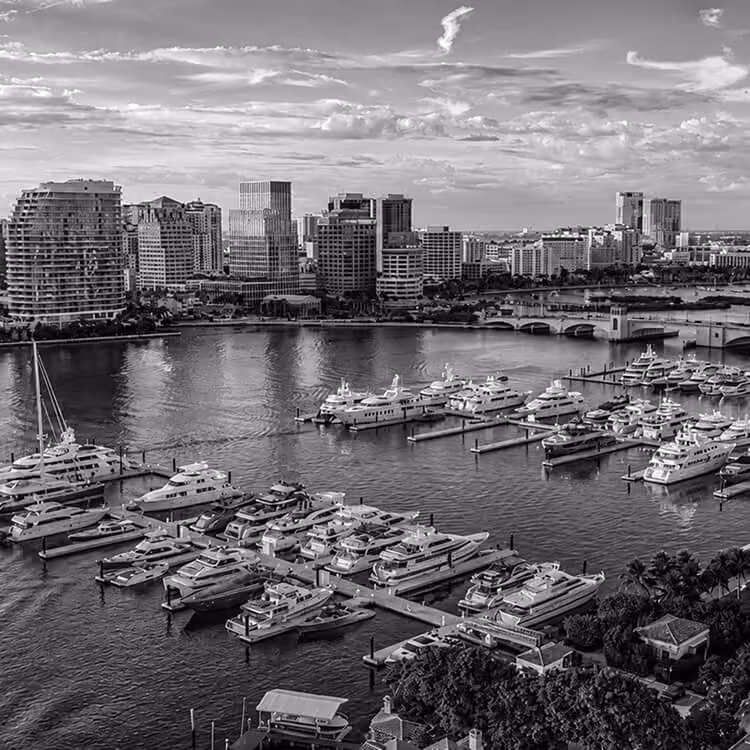 West Palm Beach marina skyline featuring luxury yachts, waterfront residences, and city views.