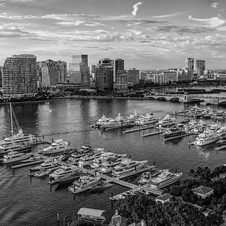 West Palm Beach marina skyline featuring luxury yachts, waterfront residences, and city views.