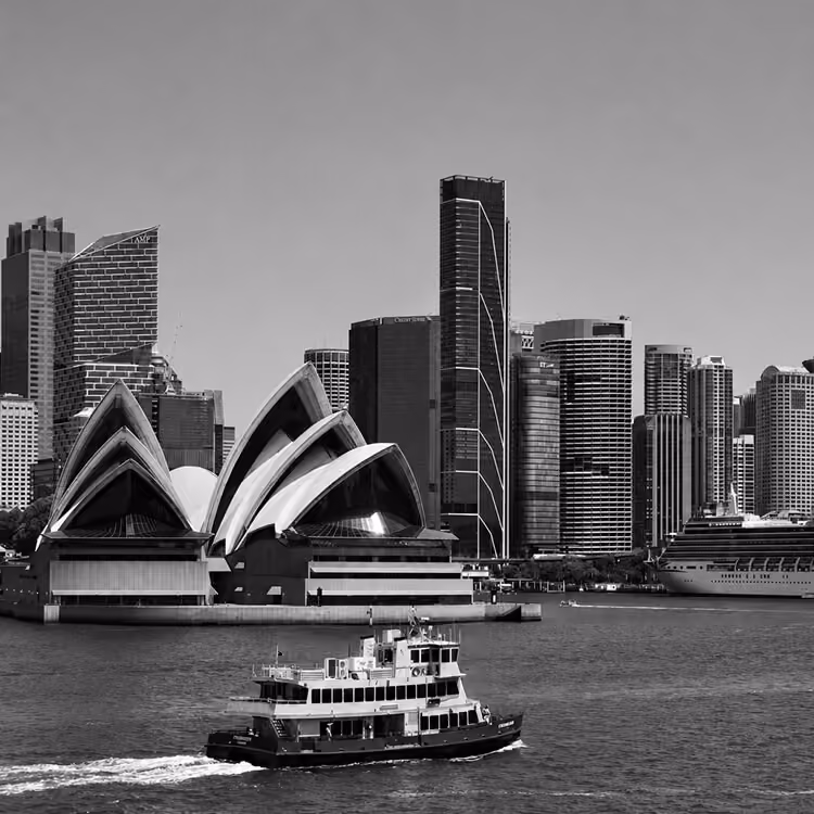 Sydney Opera House and harbour ferry framed by the city’s downtown skyline.