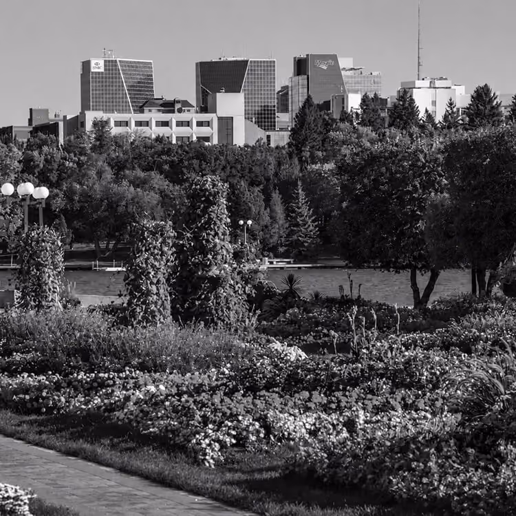 Regina skyline rising above lush greenery and the Wascana Centre parklands.