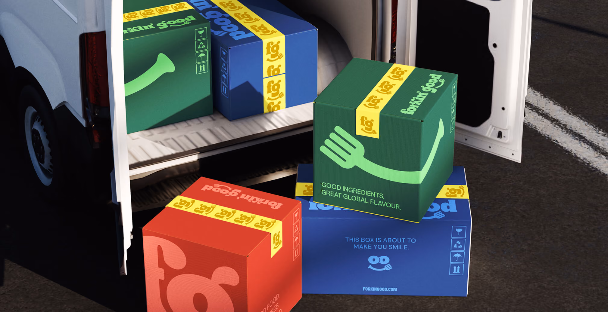 Stack of colorful Forkin’ Good branded shipping boxes placed at the back of a delivery van, featuring playful illustrations and bold packaging graphics.