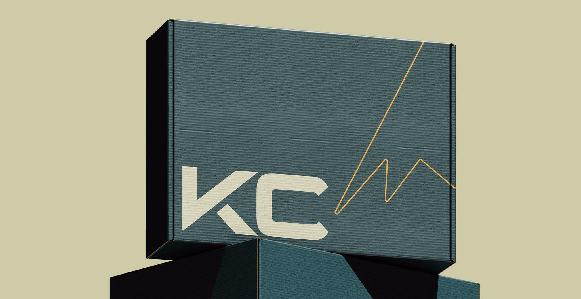 Minimal branded packaging box featuring oversized KC logo, textured dark teal surface, and gold line graphic accents.