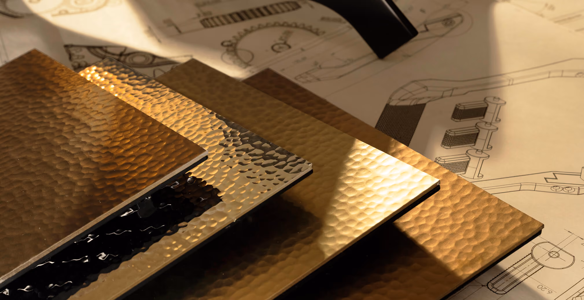 Collection of textured metallic material samples displayed over product engineering drawings, illustrating the design and development process behind the Milton Coffee machine.