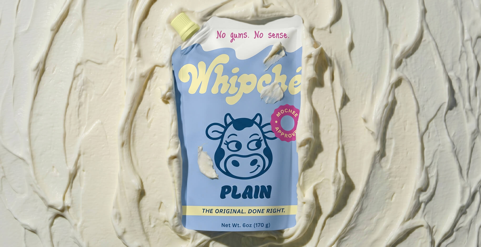 Whipché plain cream cheese pouch placed on a textured spread of cream cheese, highlighting innovative packaging design and clean ingredient messaging.
