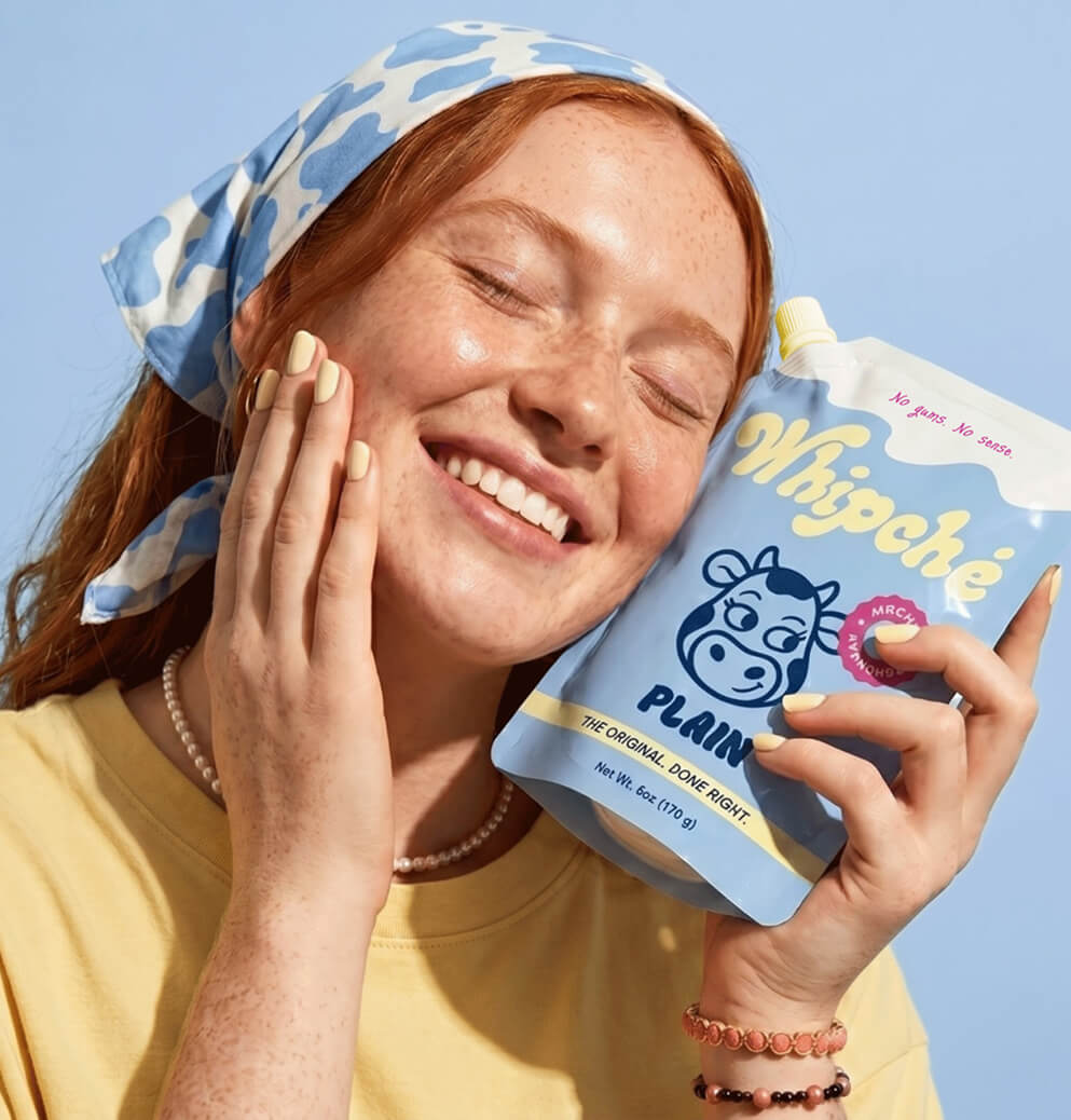 Consumer smiling while holding a pouch of Whipché plain cream cheese, showcasing brand affinity, packaging design, and lifestyle-focused marketing imagery.