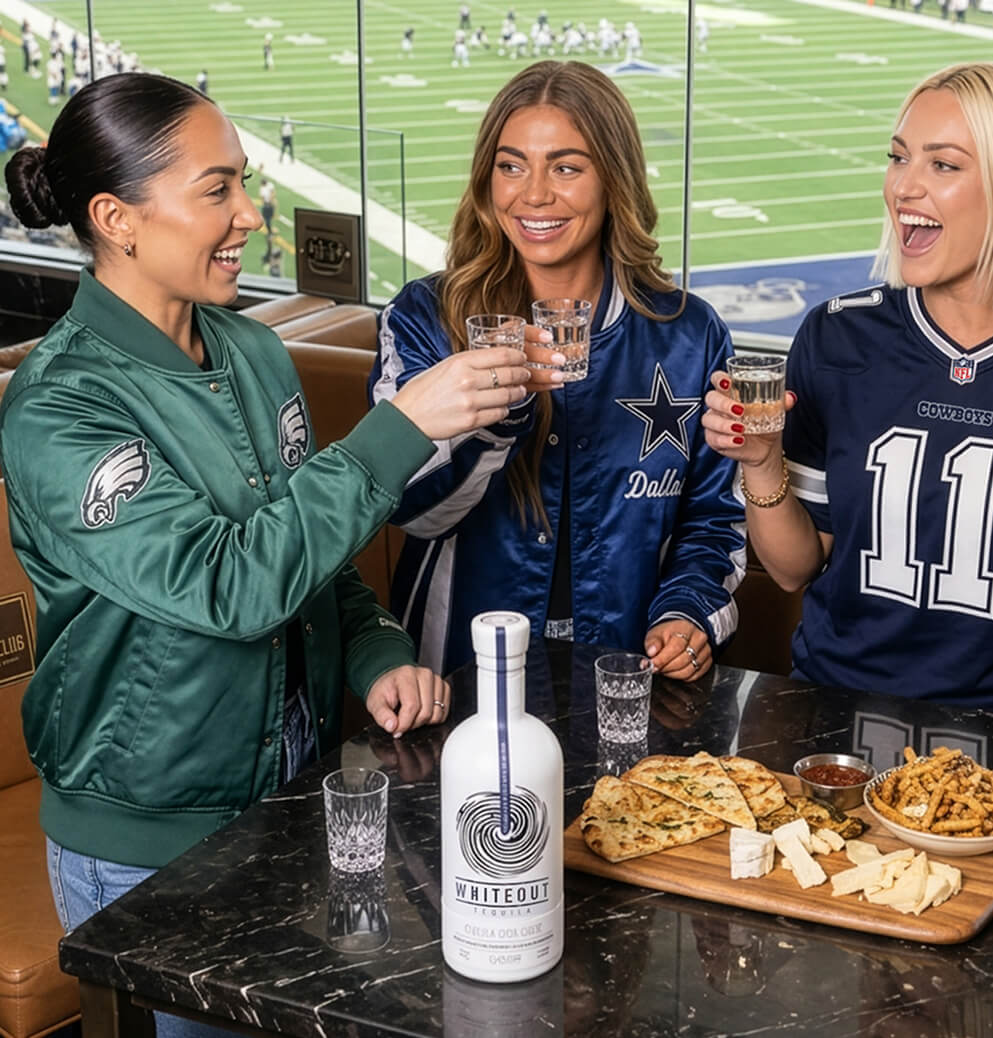Group of sports fans enjoying tequila shots in a stadium suite with Whiteout Tequila prominently featured, showcasing lifestyle marketing and brand engagement.
