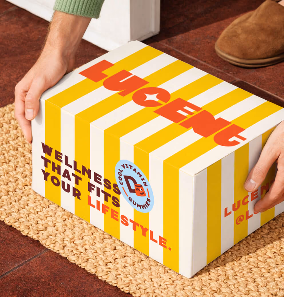 Person placing a Lucent Sun branded shipping box with yellow-and-white stripes and bold typography on a woven floor mat inside a home entryway.