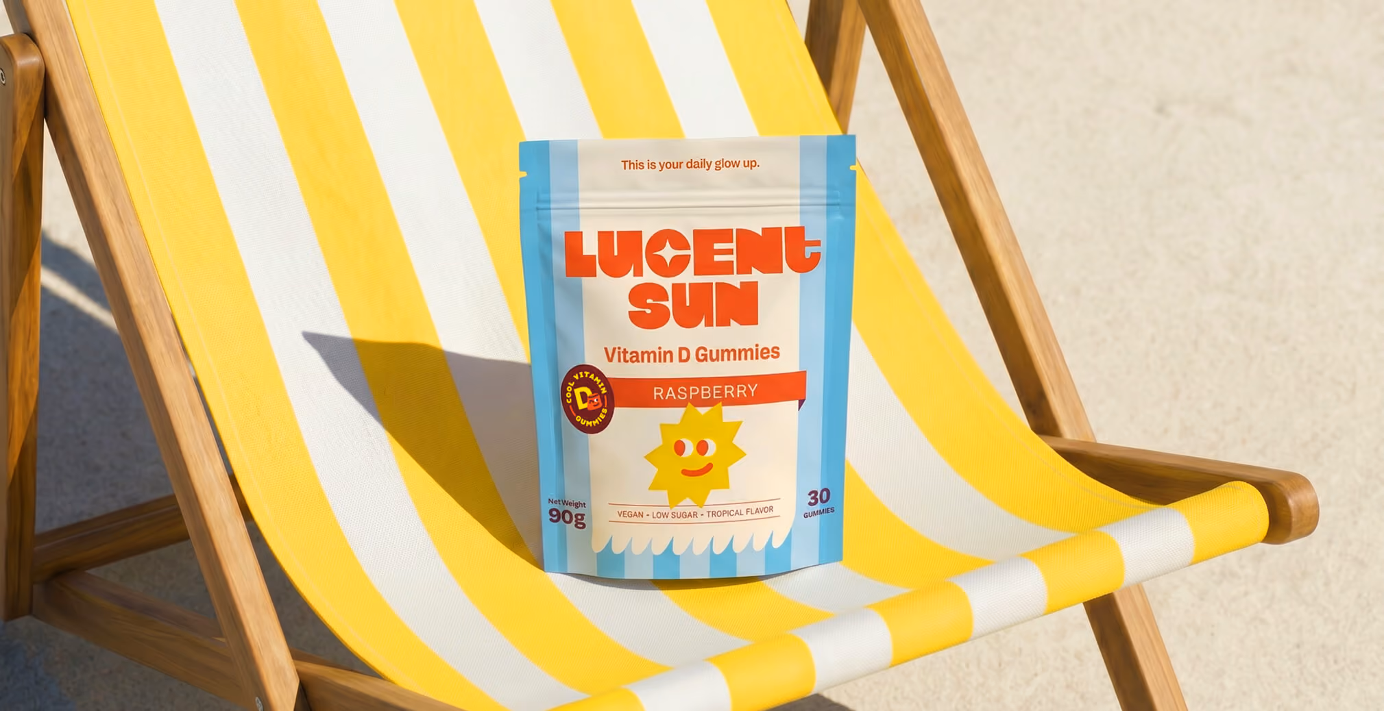 Lucent Sun Vitamin D Gummies pouch displayed on a yellow-and-white striped beach chair, highlighting bright packaging and sunny lifestyle branding.