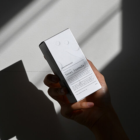 Consumer holding a skincare product box with clean typography and understated branding, highlighting packaging design that builds trust through clarity and elegance.