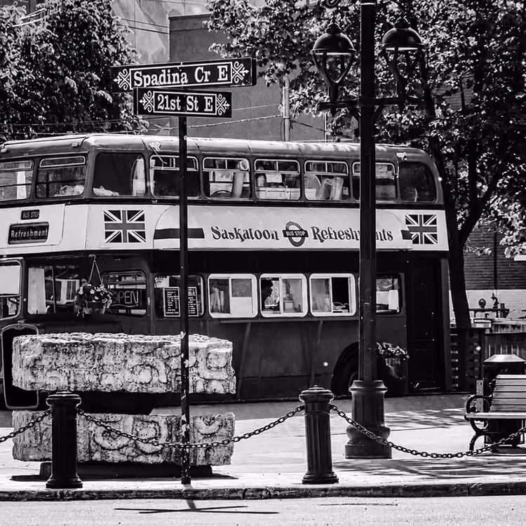 Vintage double-decker bus parked in downtown Saskatoon near Spadina Crescent.