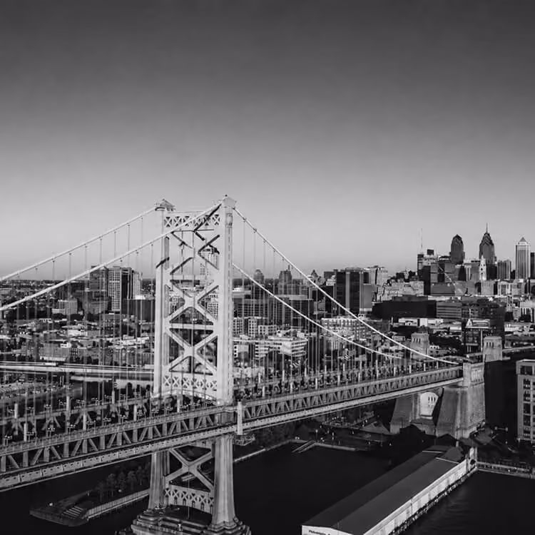 Benjamin Franklin Bridge stretching across the Delaware River with the Philadelphia skyline beyond.