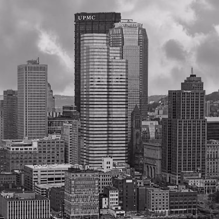 Downtown Pittsburgh skyline featuring the U.S. Steel Tower, UPMC headquarters, and surrounding high-rise buildings.