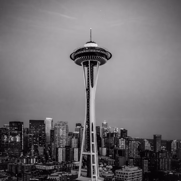 The Seattle Space Needle rising above the downtown skyline at dusk, showcasing the city’s iconic architectural landmark.