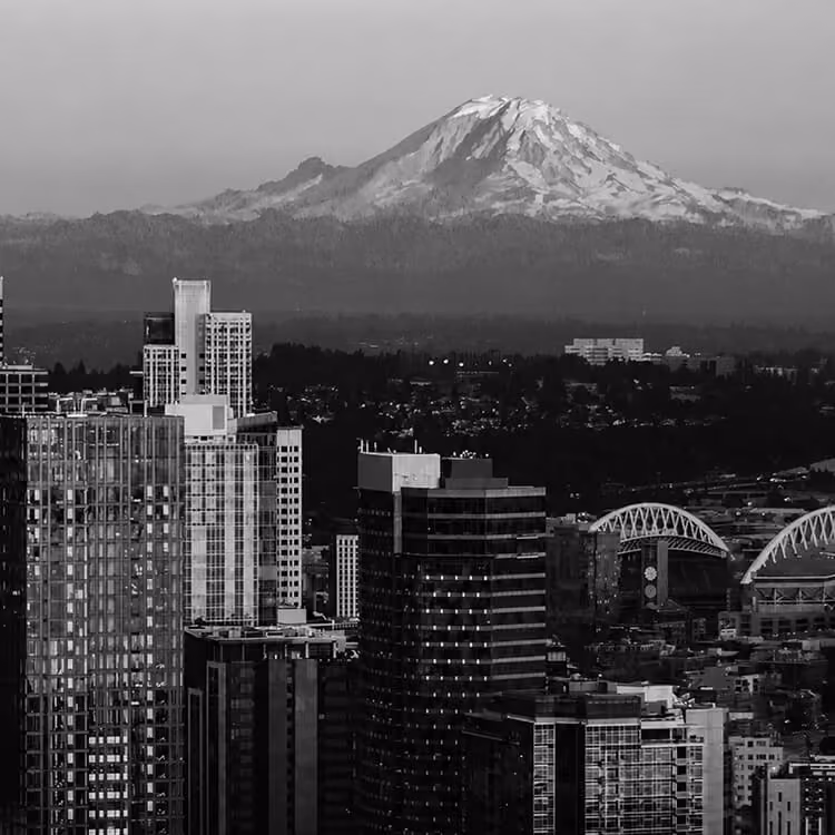 Seattle skyline with Mount Rainier towering in the background, highlighting the city's unique urban and natural landscape.