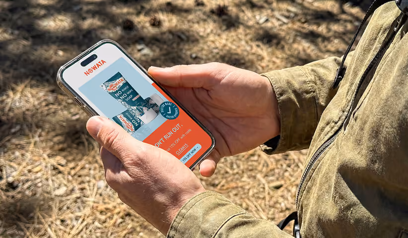 Customer browsing a Shopify ecommerce website on a smartphone outdoors, demonstrating responsive mobile commerce, product discovery, and seamless shopping across devices.