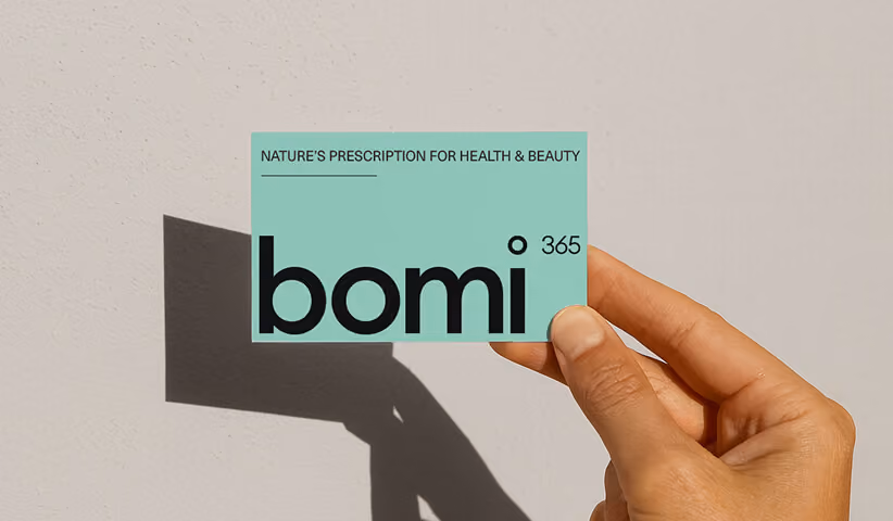 Hand holding a minimalist branded business card with modern typography, demonstrating professional brand identity design, stationery, and cohesive visual branding.