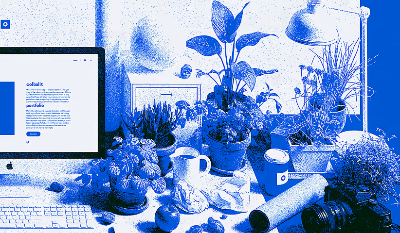 Creative desk with laptop, camera, and design equipment.