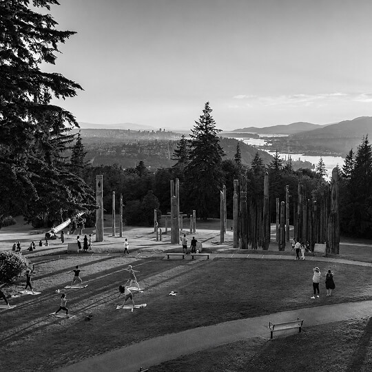 Burnaby Mountain Park overlooking the city and Burrard Inlet, featuring the iconic Kamui Mintara totem pole sculptures.