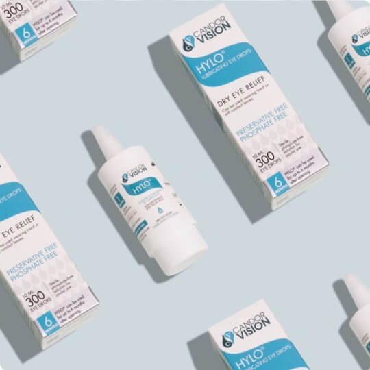 Product photography of CandorVision HYLO Dry Eye Relief eye drops and packaging arranged in a clean, minimalist flat lay.