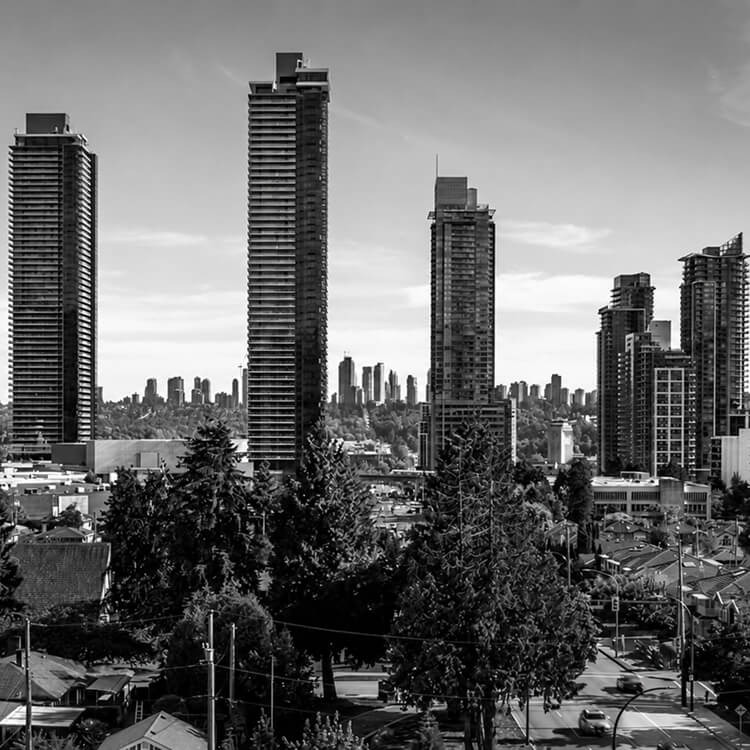 Burnaby’s Metrotown skyline featuring modern residential towers surrounded by established neighbourhoods and evergreen trees.