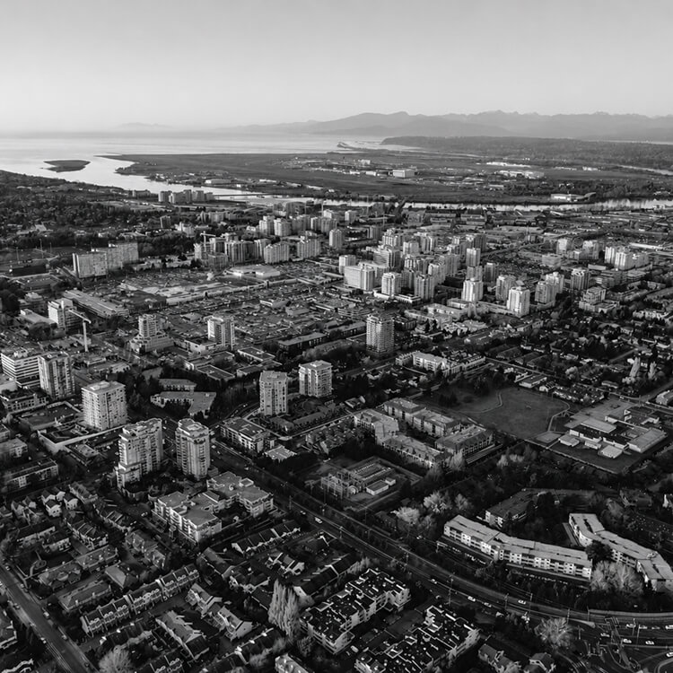 Aerial view of Richmond, British Columbia, showcasing residential neighbourhoods, commercial districts, and the Fraser River delta landscape.