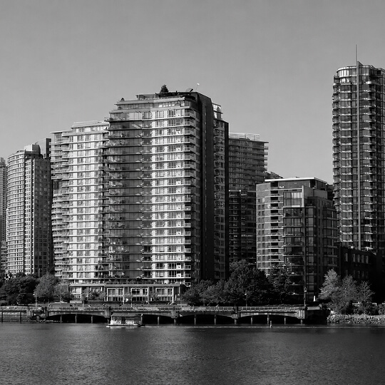 Waterfront view of New Westminster featuring modern residential towers rising along the Fraser River.