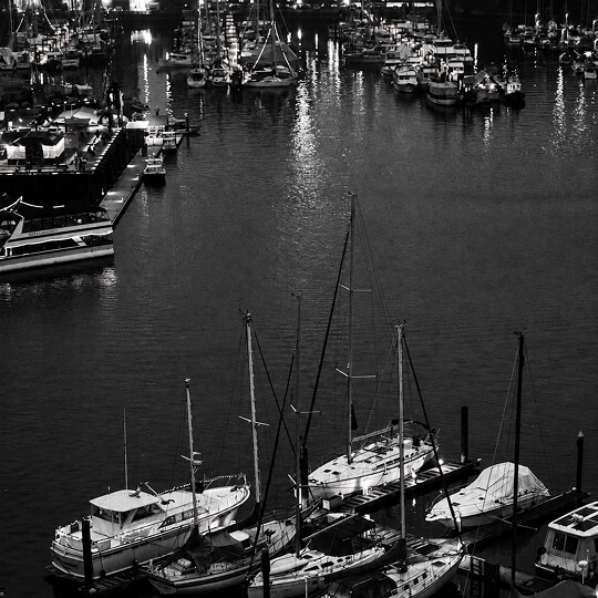 Sailboats and recreational vessels docked at a marina along the Port Moody waterfront.