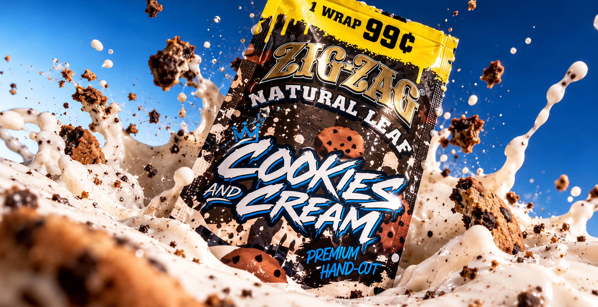 Zig-Zag Natural Leaf Cookies and Cream wrap package surrounded by splashing cream and chocolate cookie pieces against a bright blue background.
