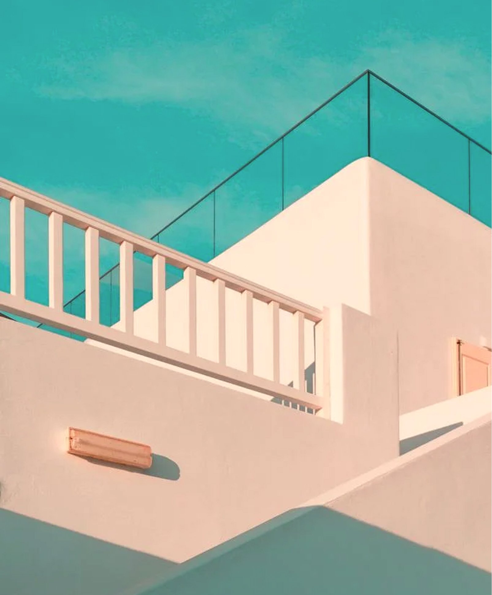 Minimalist building with soft pink walls, white railings, and glass balcony under a clear turquoise sky.