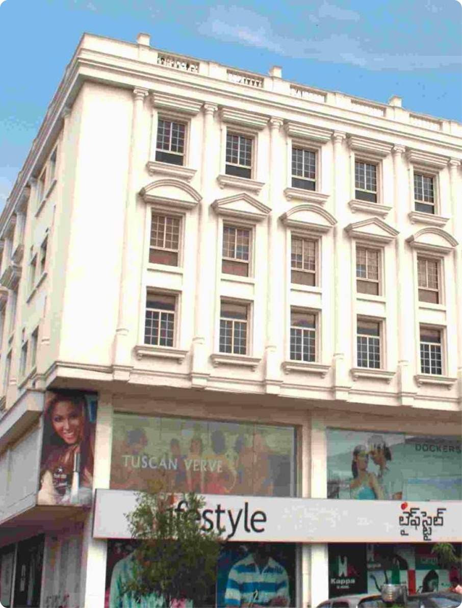Multi-story white building with decorative windows and a retail store named Lifestyle on the ground floor.