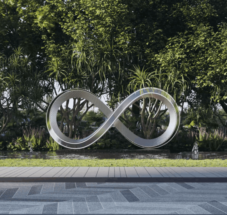 Metallic infinity symbol sculpture suspended above a shallow water feature with green plants and trees in the background.