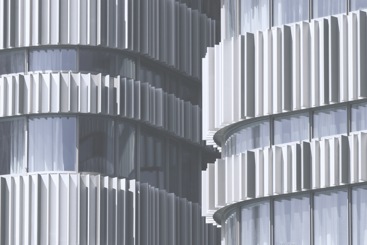 Two curved towers with ribbed cladding, representing the fund tiers that decide who can invest in the UAE