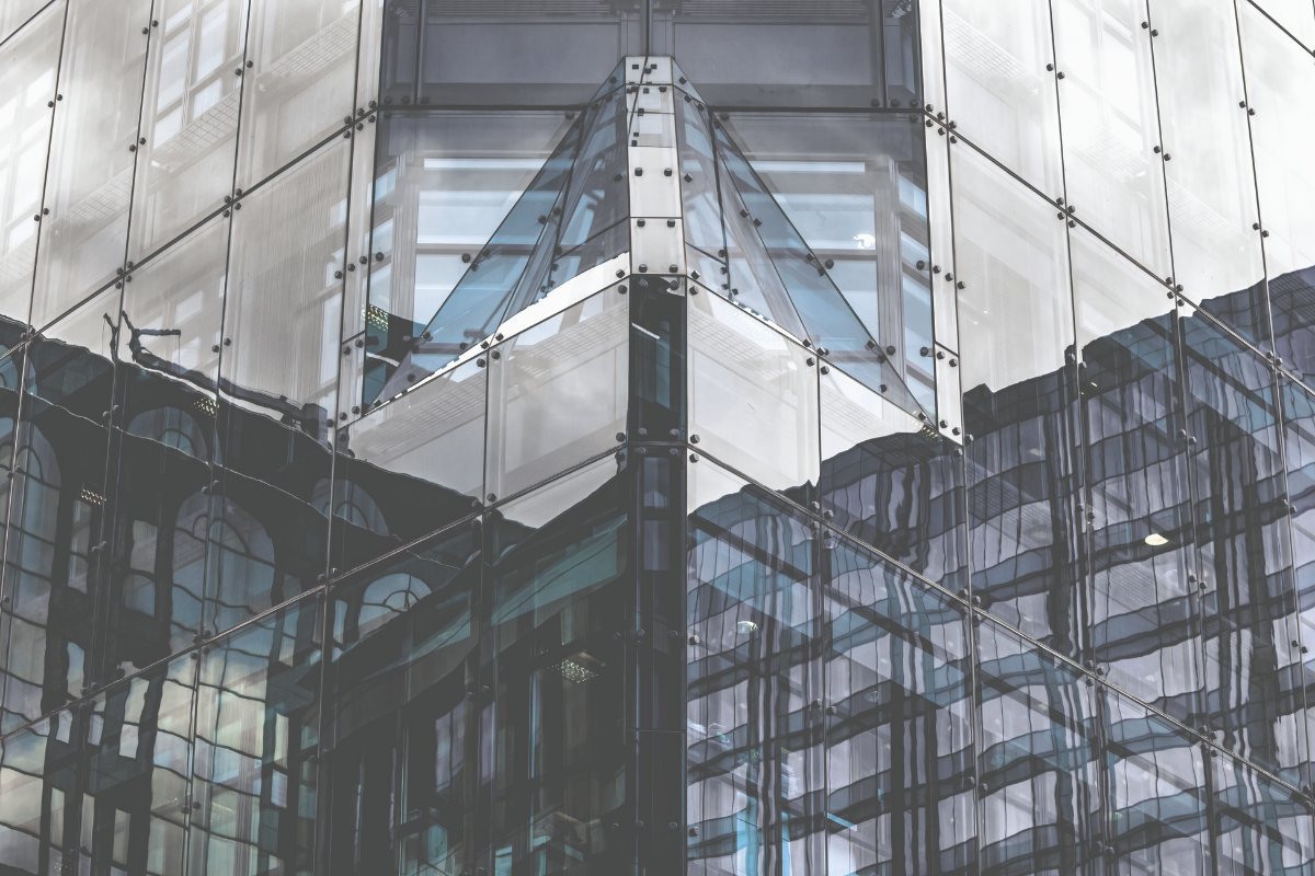 Reflective glass corner of a modern building, representing redemption at net asset value in stressed markets