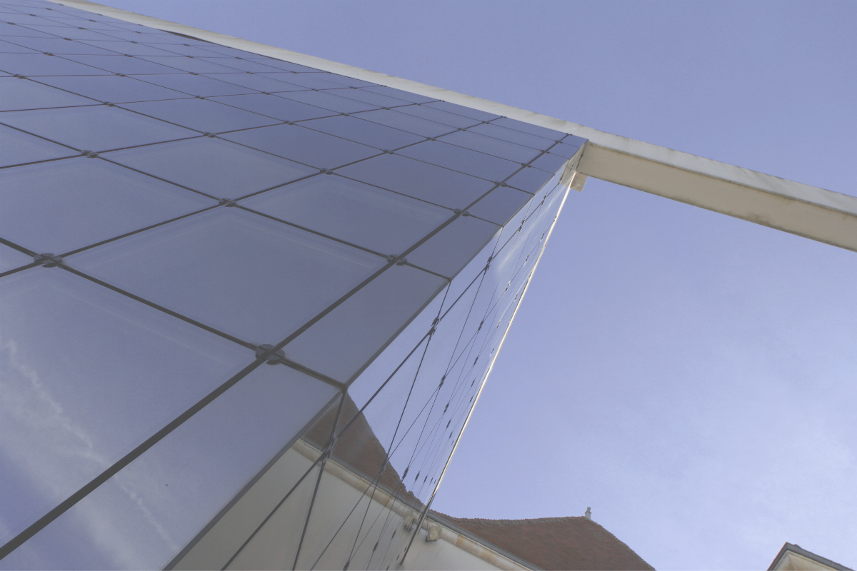 Glass facade rising against the sky, representing the two sides of the Swiss franc as a safe haven