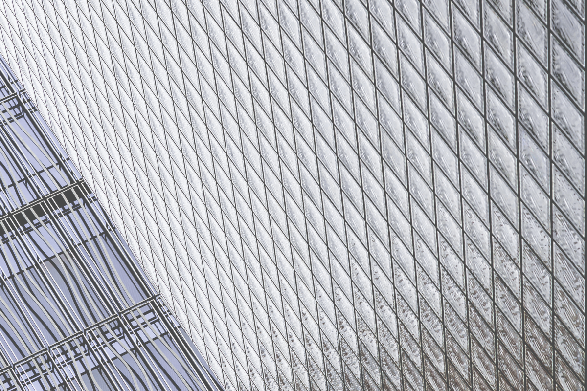 Fine-grid high-rise facade, representing the compounding cost of holding an ETF or a mutual fund