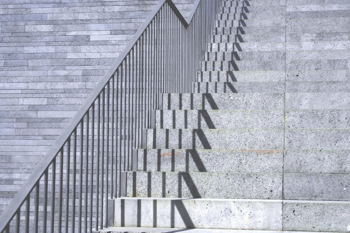 Stone staircase with a metal railing, representing the steps of opening a Swiss bank account as a foreigner