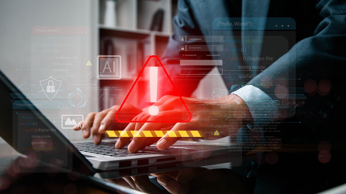 User typing on a laptop with a security alert symbol, illustrating potential AI misuse or prompt-based attacks
