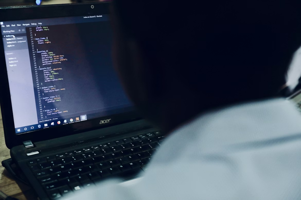 Developer reviewing source code on a laptop, representing LLM prompt injection detection and AI security analysis