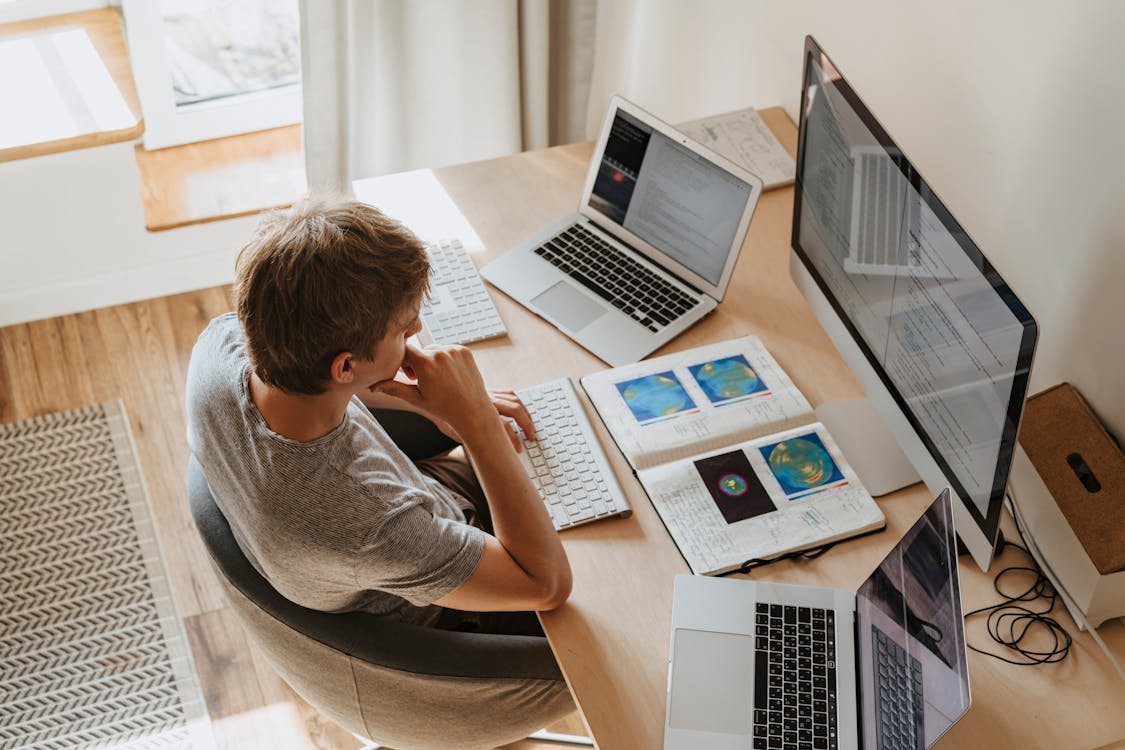 Engineer reviewing code and data across multiple devices in an AI development workspace
