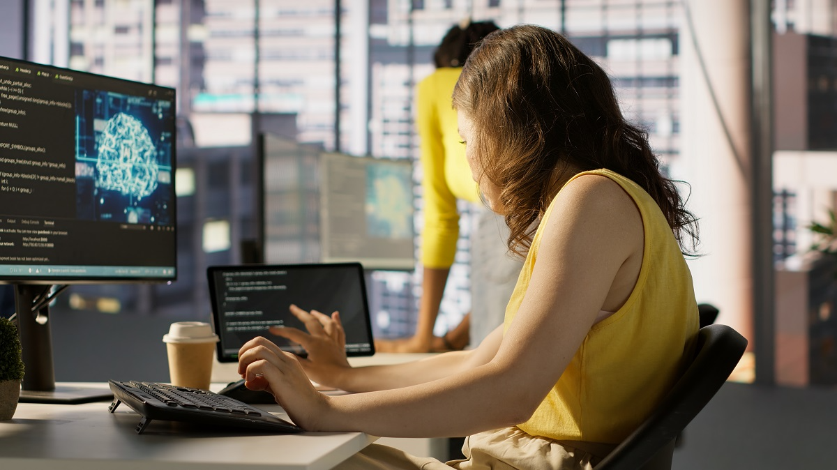 AI engineer reviewing machine learning model code on computer screens in a modern office