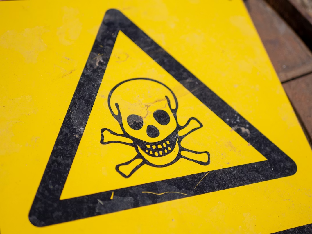 Hazard sign with a skull and crossbones symbol representing the danger of data poisoning attacks