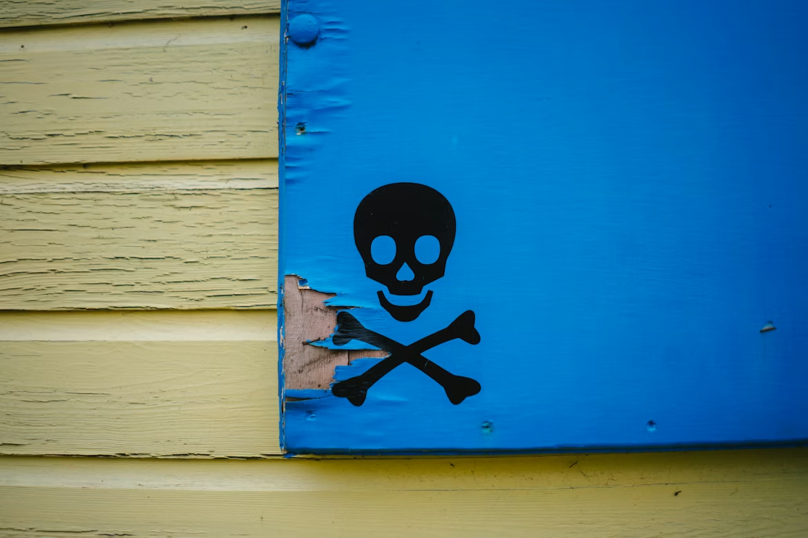 Skull and crossbones painted on a damaged blue panel illustrating the hidden threat of data poisoning