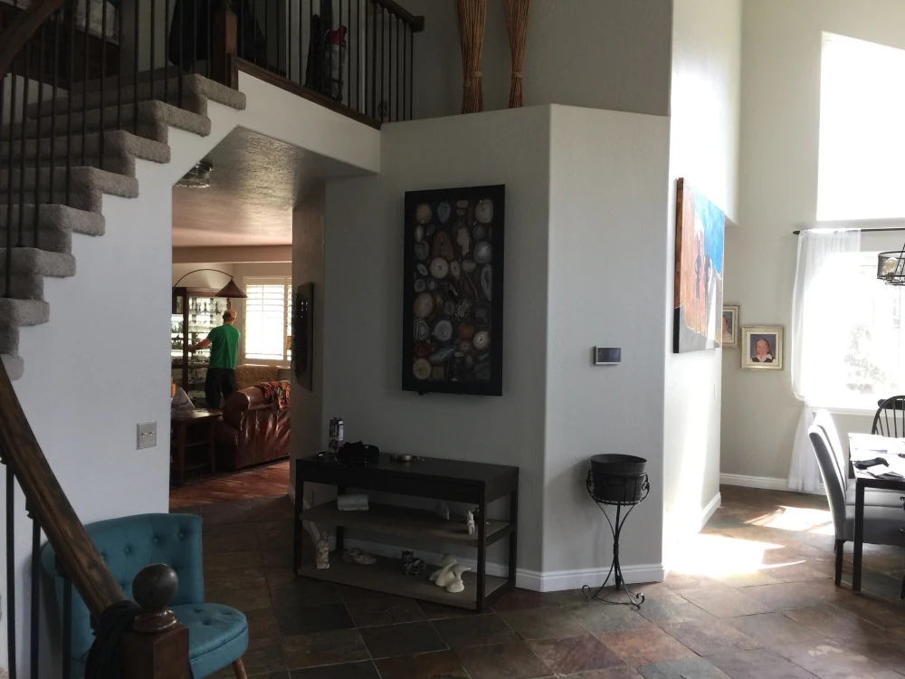 Dark entryway with slate tile flooring and carpeted staircase before a whole house remodel in Salt Lake City