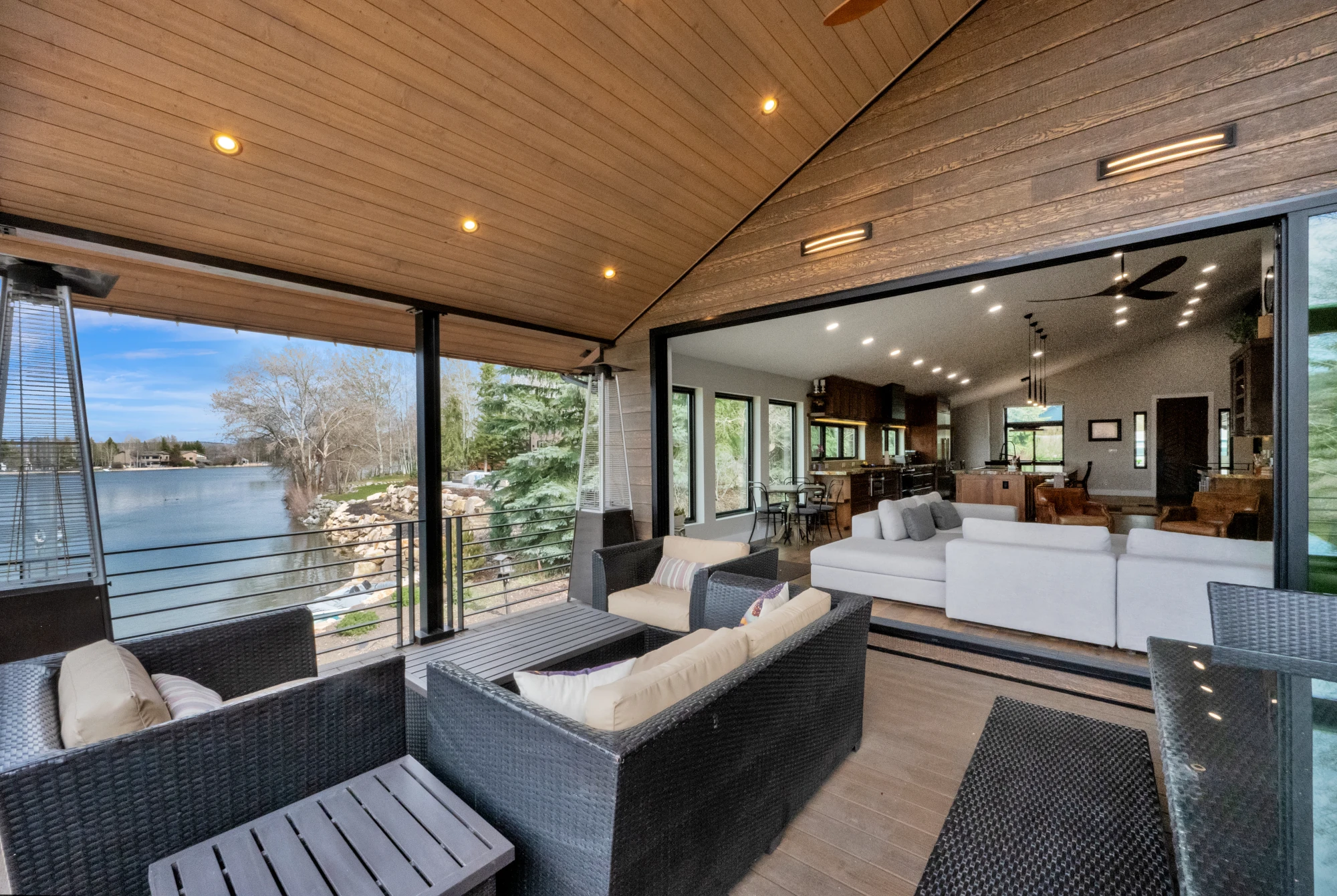 Modern rustic home exterior with dark wood siding, stone veneer base, and a stamped concrete entry walkway