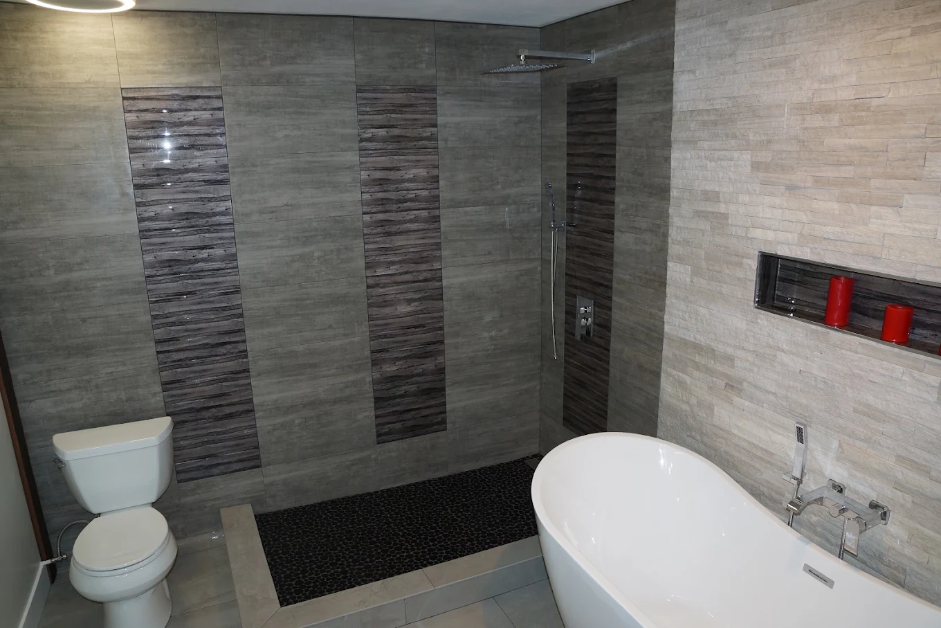 Natural stone wall and floor tile with a toilet and freestanding tub in Salt Lake City