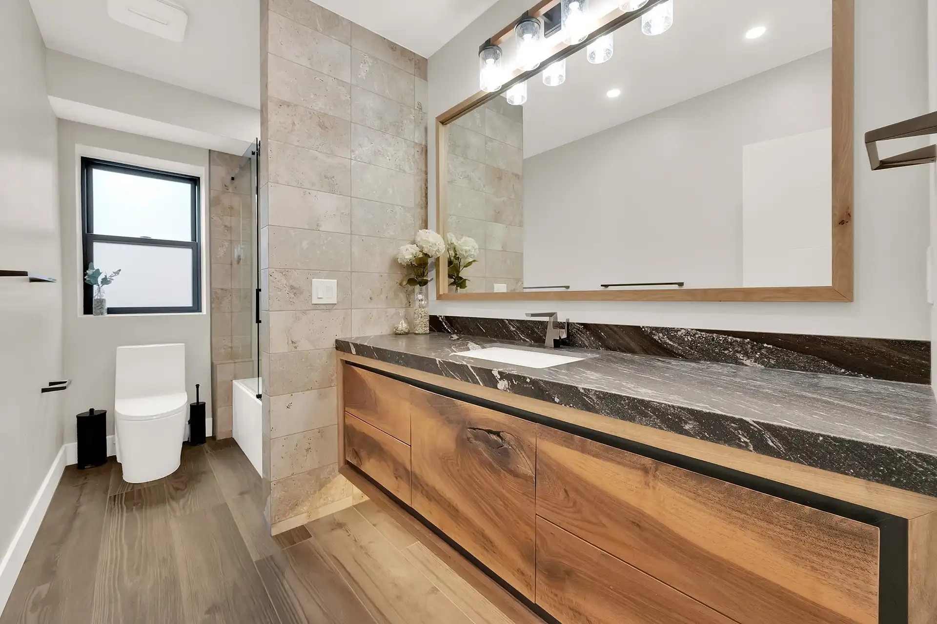 Bathroom with wood-look luxury vinyl flooring and marble countertop