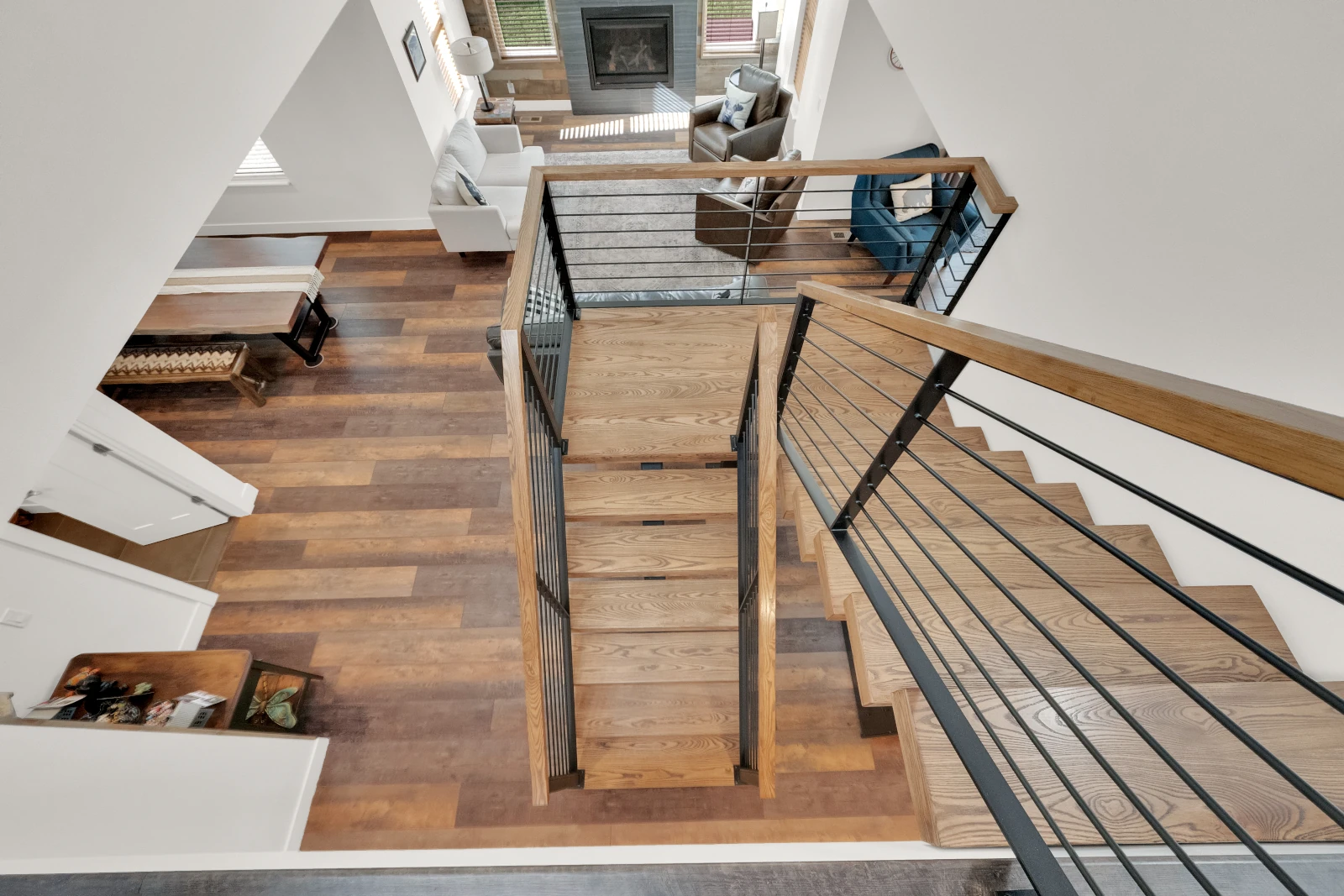 Overhead view of open-riser wood staircase and open concept living room