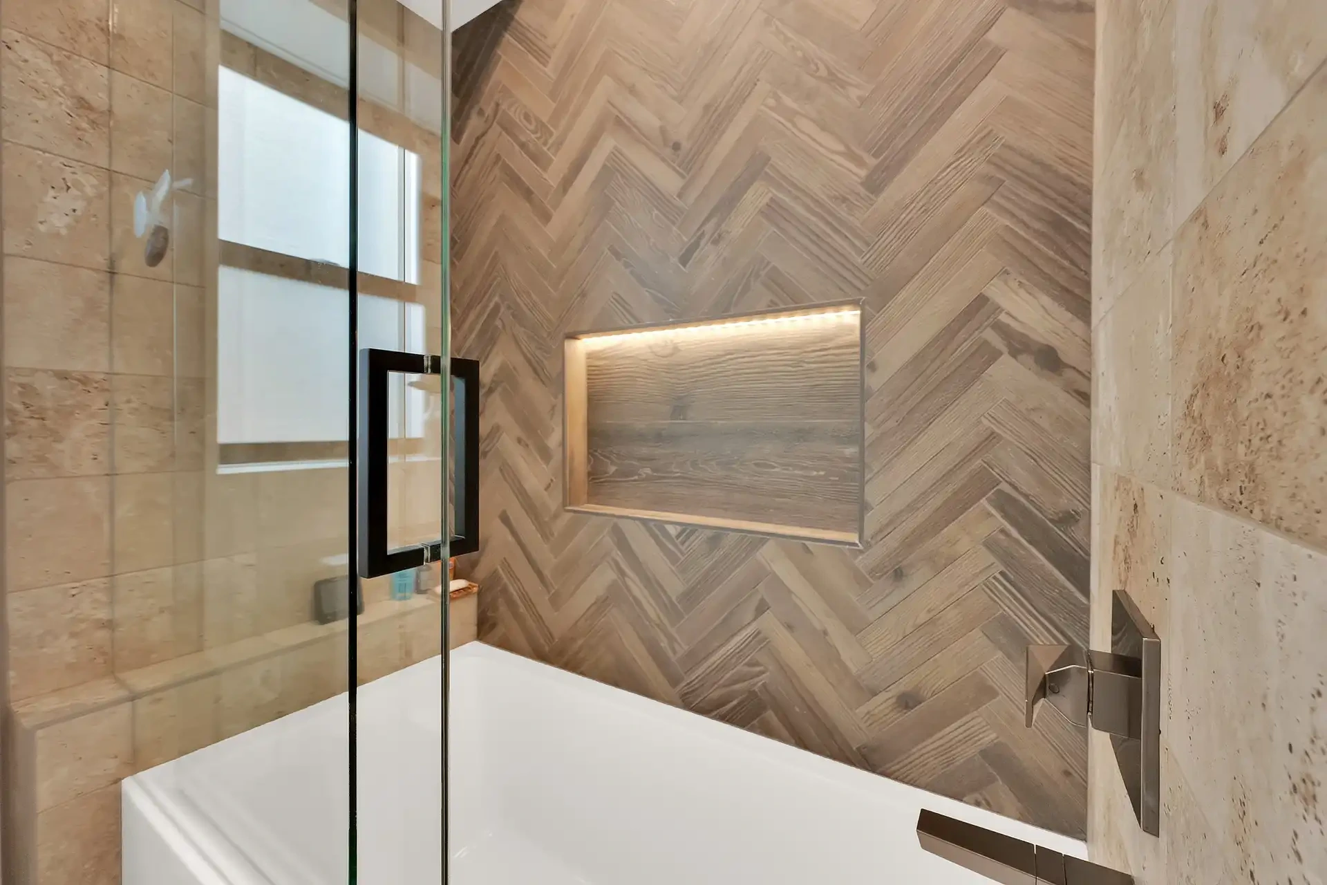 Bathtub with natural stone tile flooring and large custom cabinetry