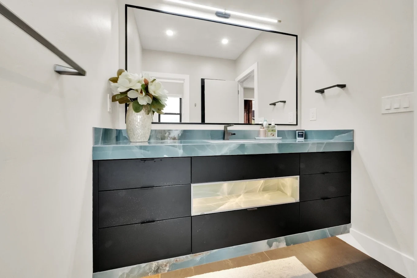 Bathroom vanity with lit full-length mirror and cabinetry below