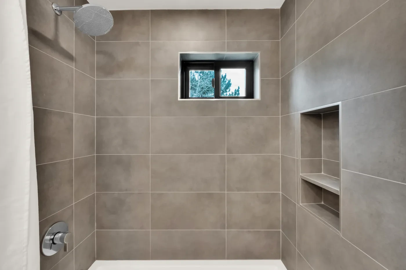 Tub surround tile with clean seam lines and bathroom niche